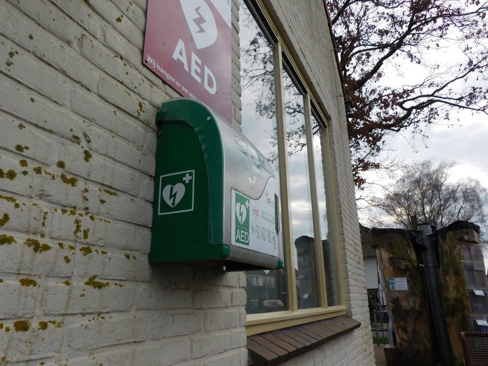 Een defibrillator aan de buitenmuur van een gebouw.